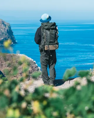 Ryan on the edge of a cliff facing the ocean